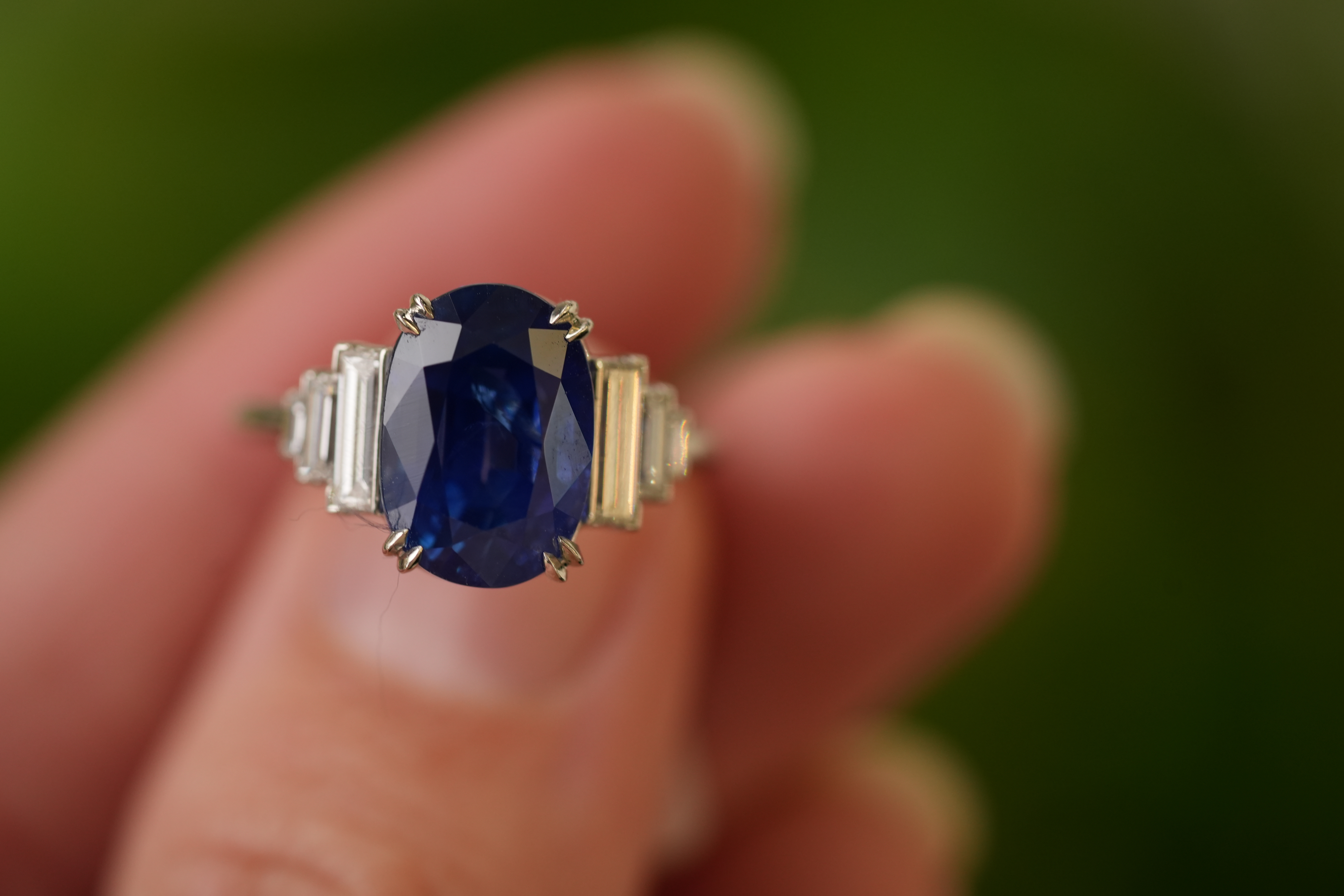A person holding a detailed panther-shaped ring with blue and silver gemstones.