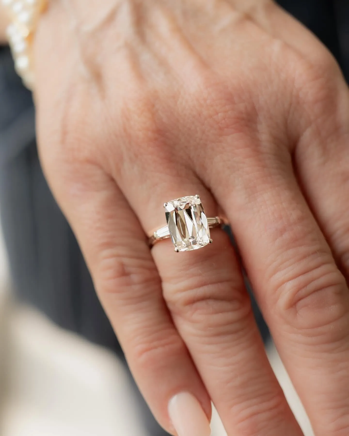 A diamond halo engagement ring with a matching wedding band in a ring box
