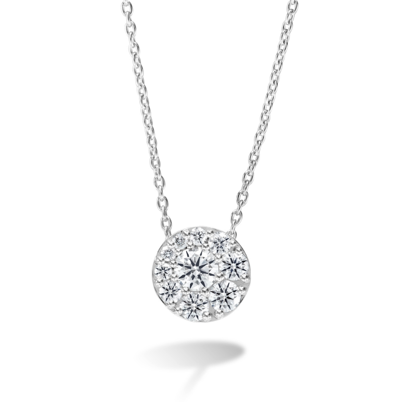A circular diamond neckless with a large diamond offset in the center, surrounded by 8 smaller diamonds.
