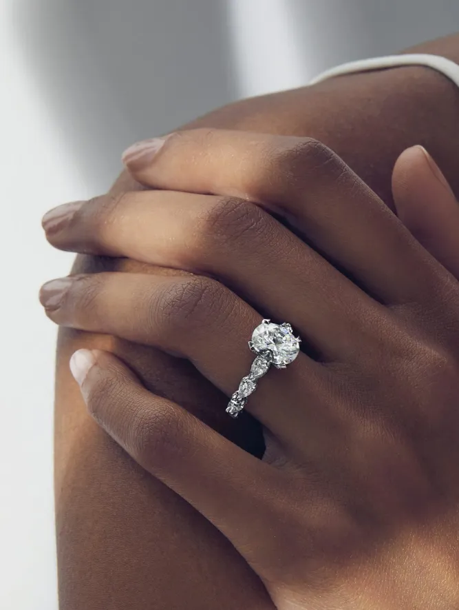 Hand with diamond engagement ring on shoulder