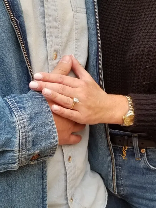 Couple holding hands, showcasing an engagement ring, symbolizing love and commitment. Visit P.J. Rossi Jewelers for fine jewelry