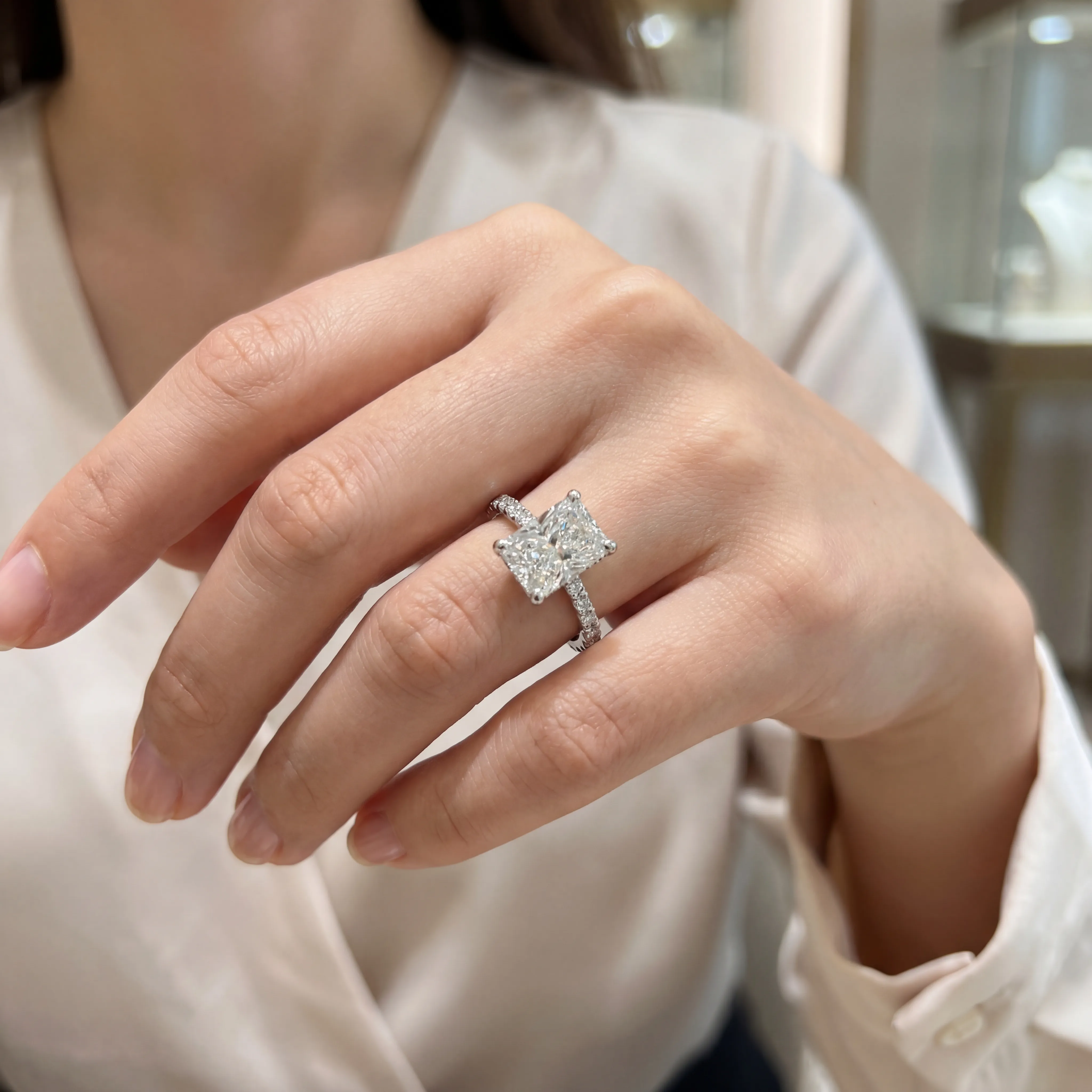 Stunning rectangular diamond engagement ring on a wooden surface, showcasing brilliance and elegance. Visit Premier Diamond Cent