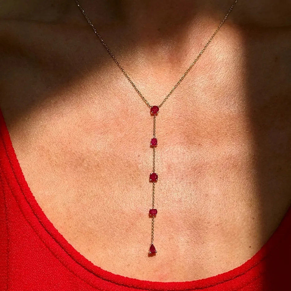 Elegant ruby and gold pendant necklace on a model.