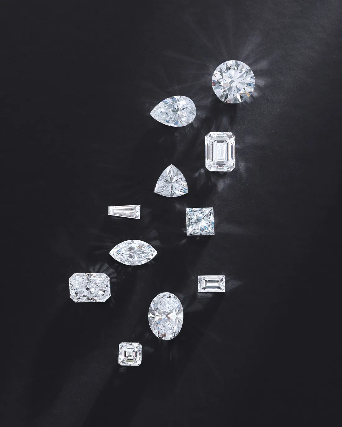 Various diamond shapes arranged on a black background. Click to shop now at Premier Diamond Center.