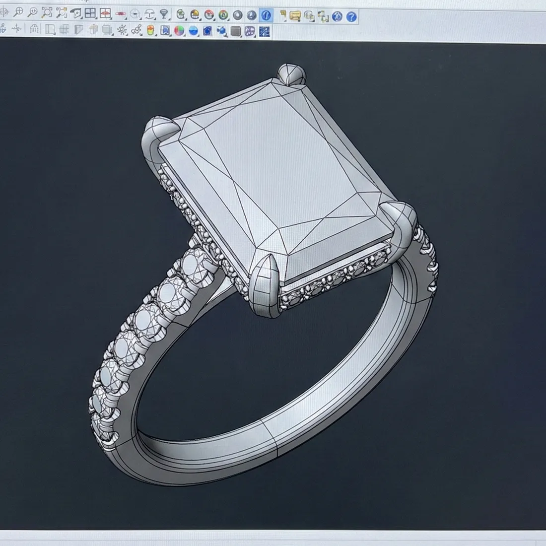 3D CAD design of an elegant engagement ring featuring a rectangular stone and a diamond-studded band.