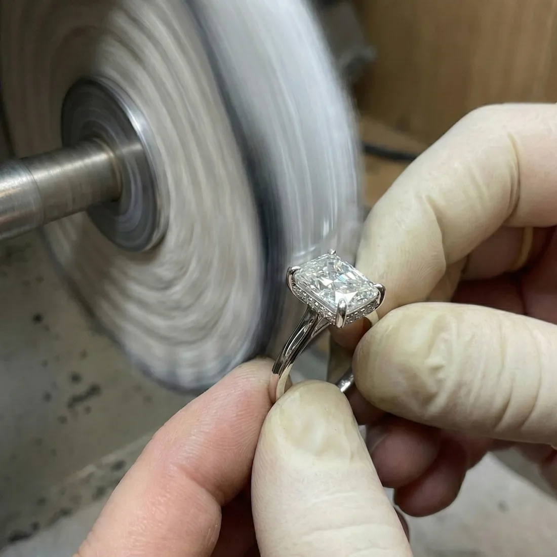 Jeweler polishing a diamond engagement ring, showcasing craftsmanship at Premier Diamond Center in Beavercreek.
