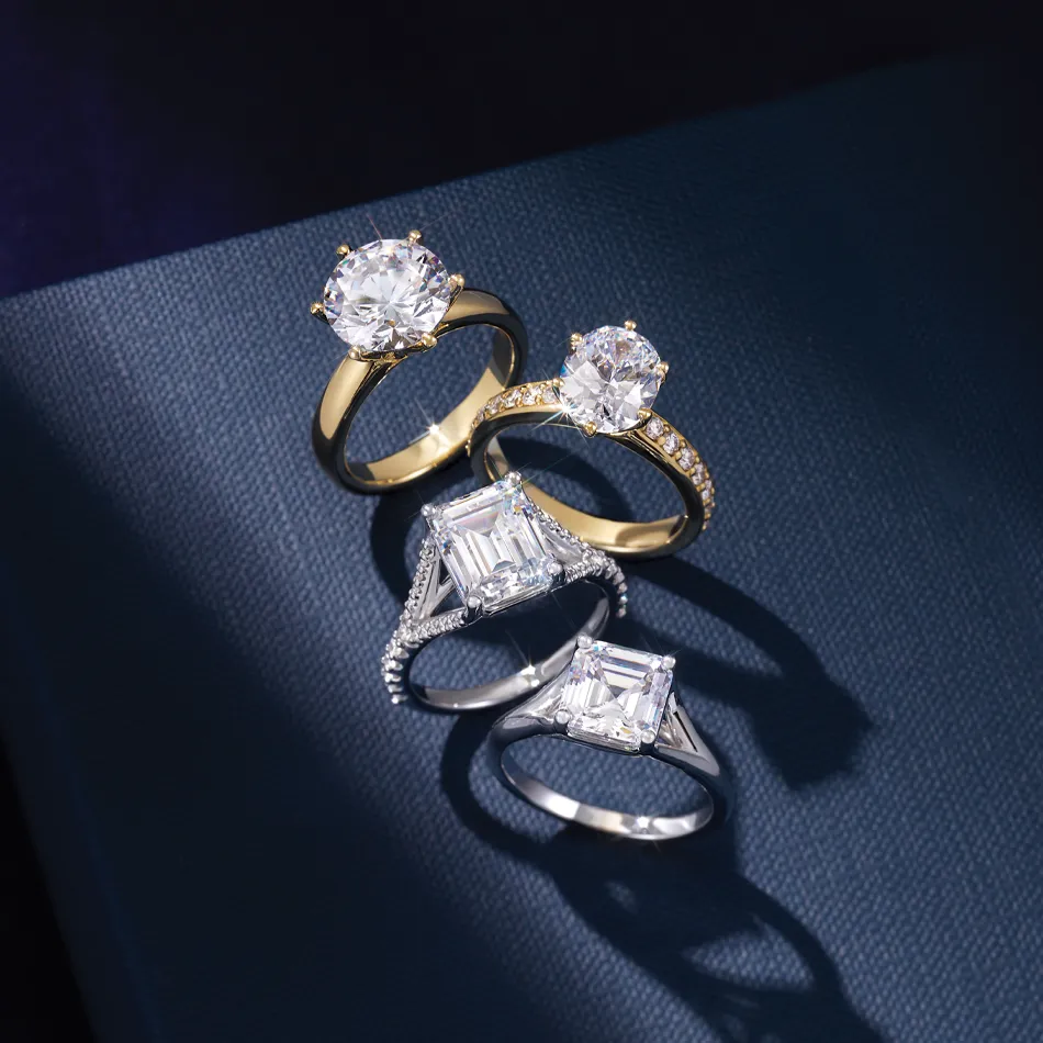 Four elegant engagement rings featuring round and emerald-cut diamonds, available at Premier Diamond Center in Beavercreek.