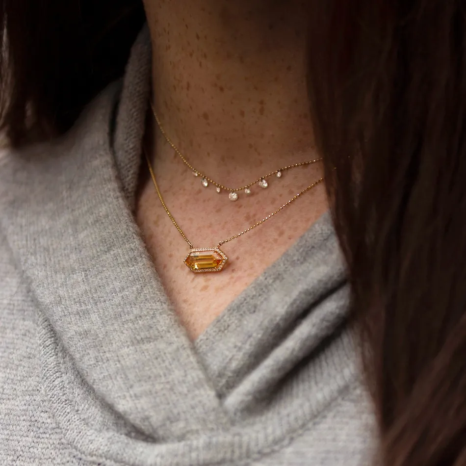 Elegant layered gold necklaces with a central gemstone.