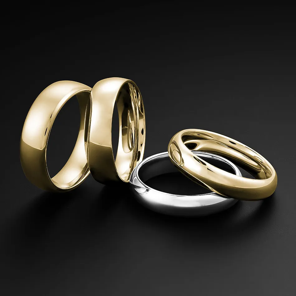 Four wedding bands: two gold and two silver, displayed against a black background. Click to explore wedding bands at Premier Dia
