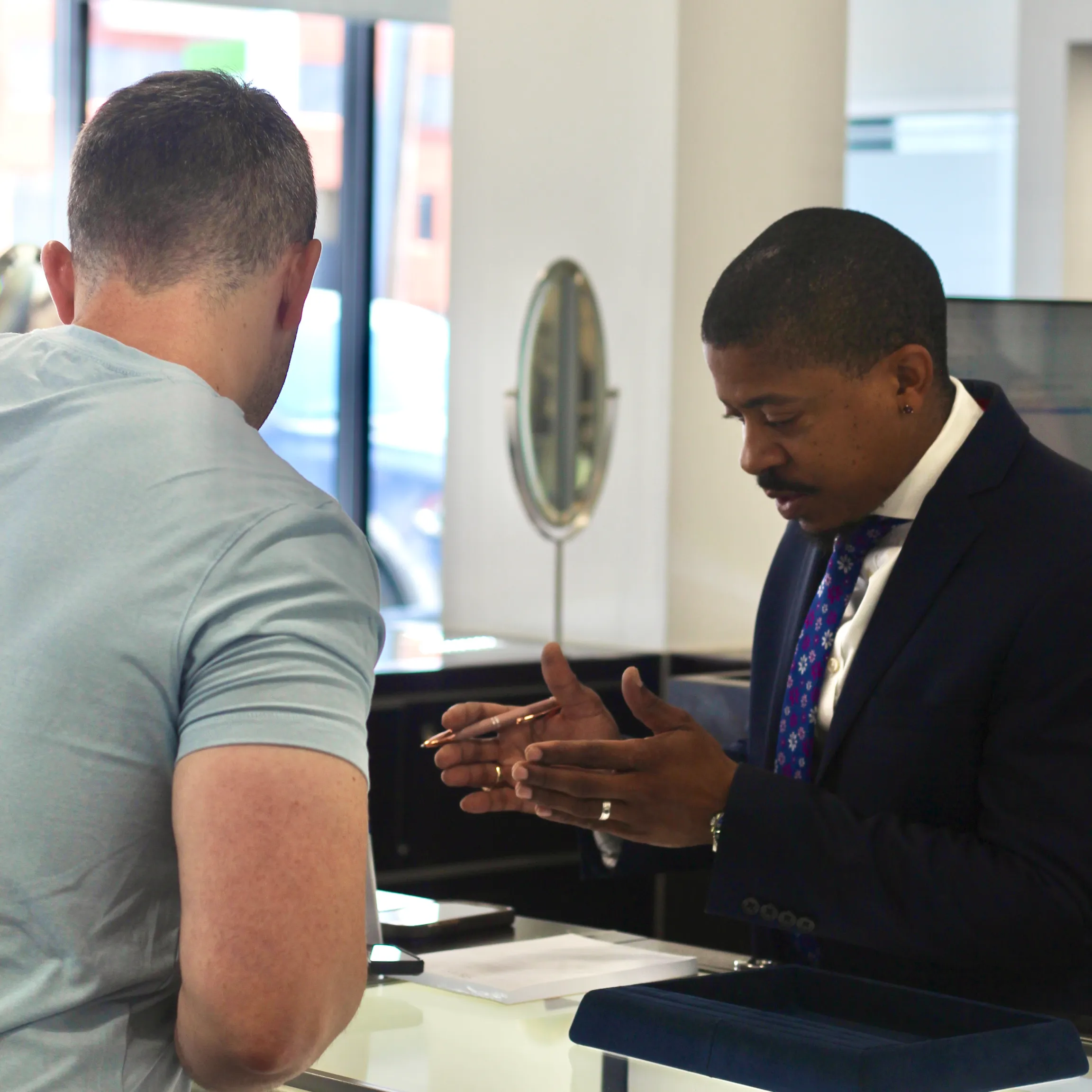 Customer consulting with a jeweler at Quest Fine Jewelers in Fairfax, discussing jewelry options.