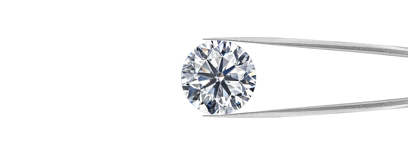 Round earth-mined diamond held by tweezers, showcasing its brilliance. 