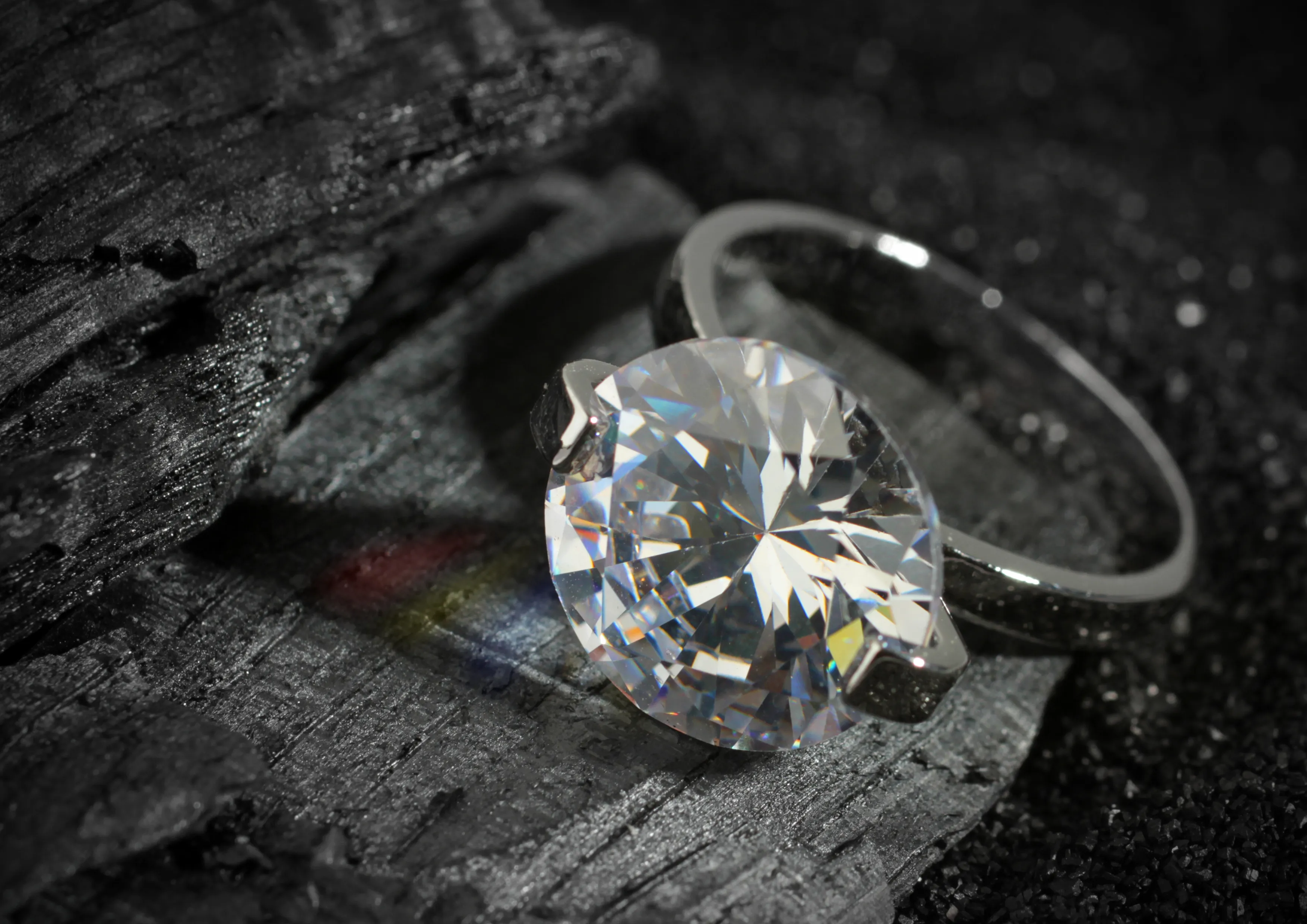 Brilliant diamond ring resting on dark wood, showcasing its sparkle and elegance.