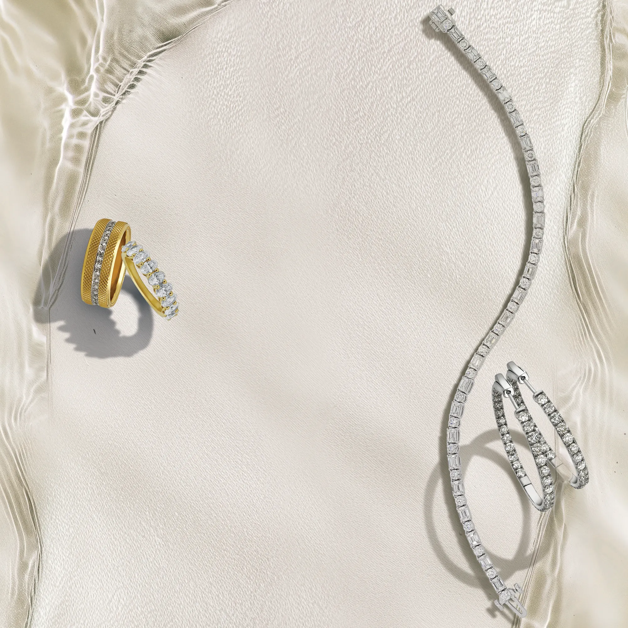 Elegant gold and silver rings with diamonds on a soft fabric background. Click to make an appointment at Quest Fine Jewelers.