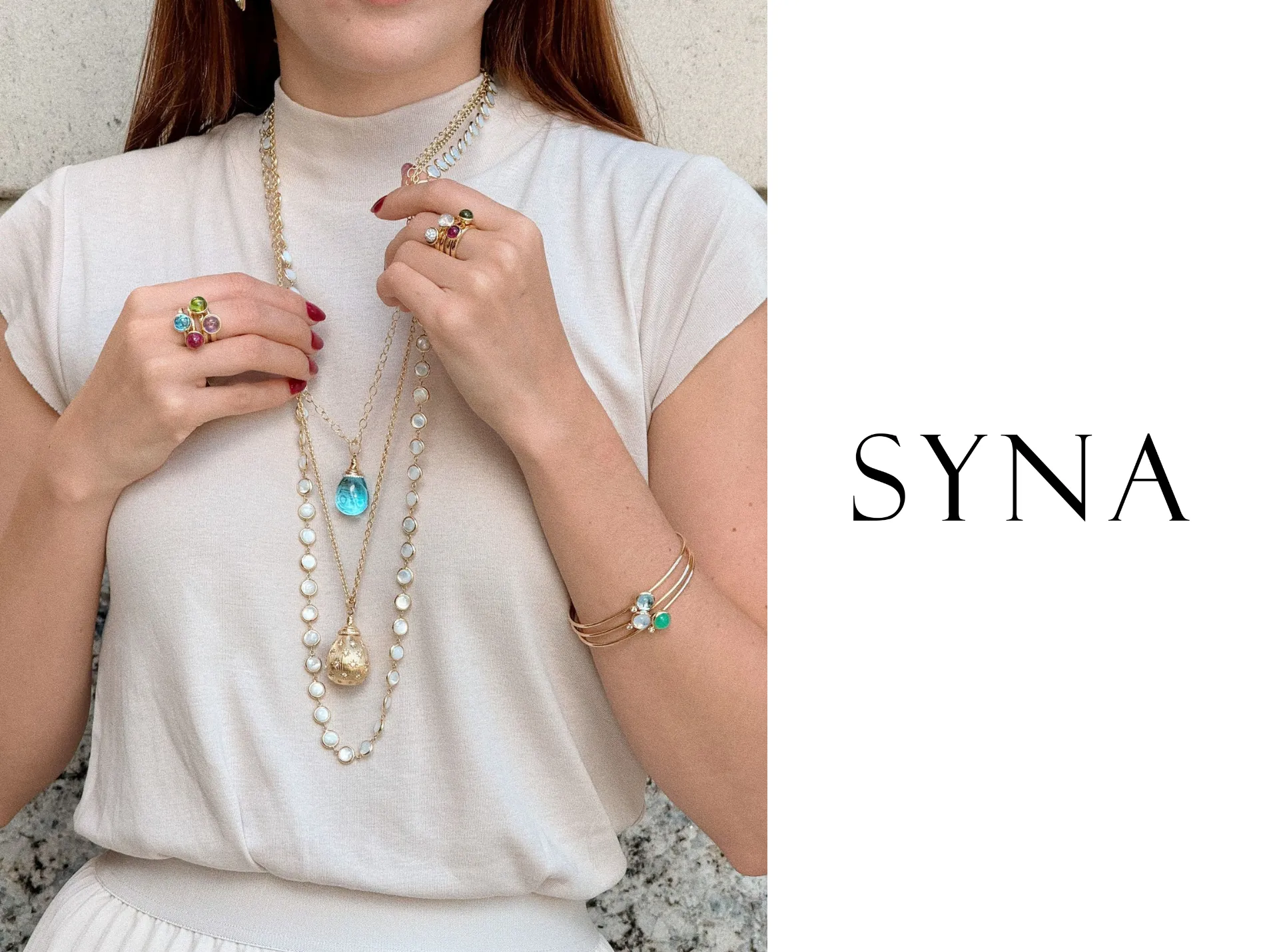 Model showcasing SYNA jewelry, featuring rings, necklaces, and earrings. Click to explore more at Quest Fine Jewelers.