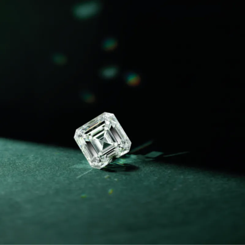 Brilliant earth-mined diamond on a dark surface, showcasing its clarity and sparkle. Learn more about earth-mined diamonds.