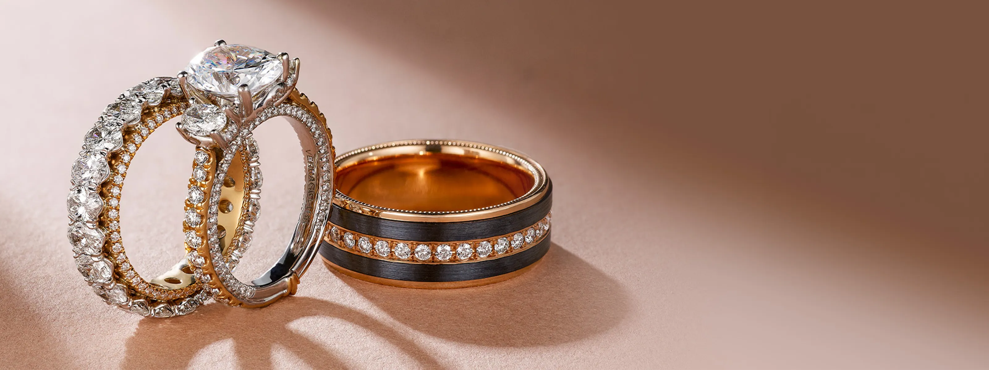 Elegant diamond engagement rings and wedding bands displayed on a soft background. Shop at Quest Fine Jewelers, Fairfax.