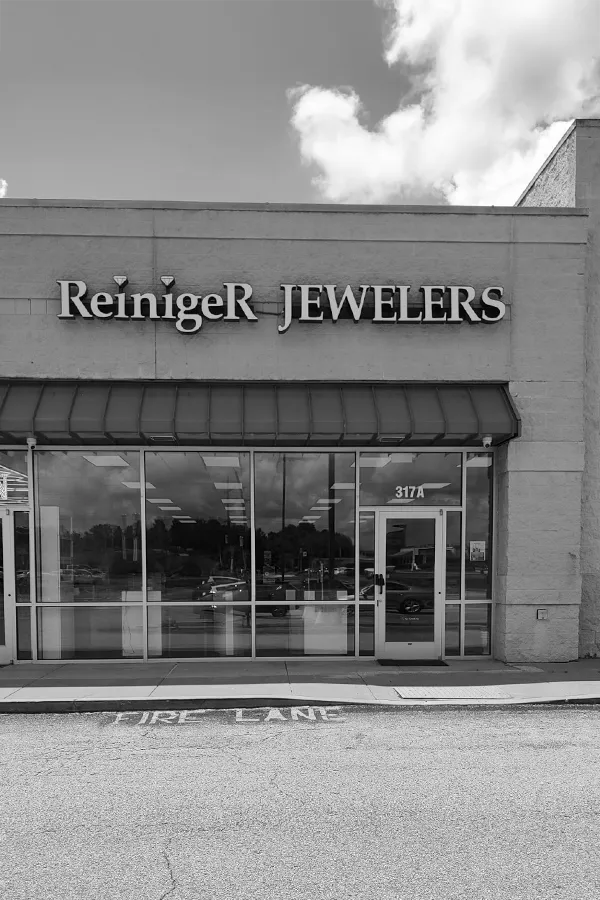 A hand holding a diamond ring on a ring sizer, measuring size 17. Visit Reiniger Jewelers for fine jewelry.