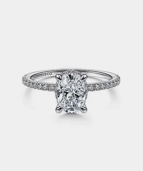 Elegant oval diamond engagement ring with a delicate band, featuring sparkling accents. Visit Reiniger Jewelers for details.