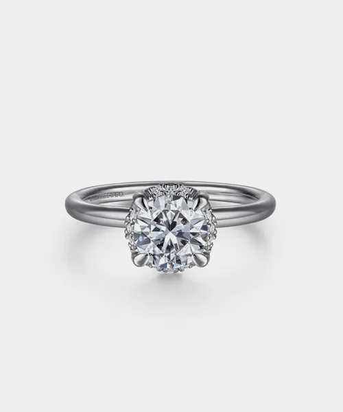 Elegant engagement ring featuring a round diamond center stone with a delicate band, showcased by Reiniger Jewelers.