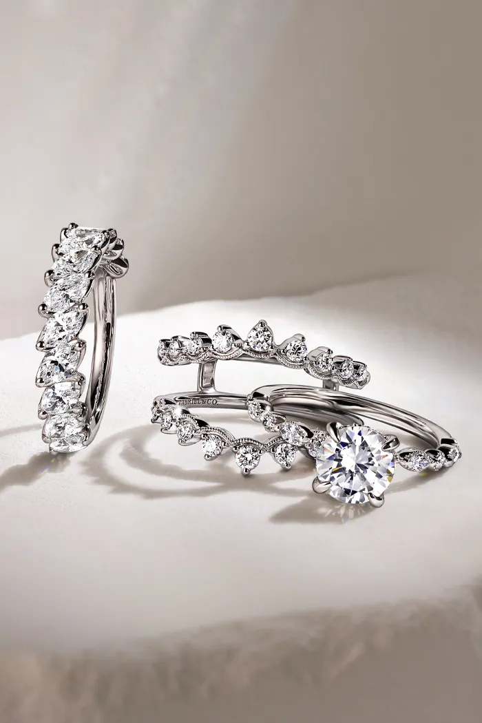 Three elegant diamond rings displayed on a soft surface, showcasing intricate designs and sparkling stones.