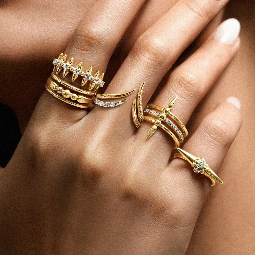 Stylish gold rings with spikes and diamonds on a hand, showcasing unique jewelry designs. Click to Shop Now at Reiniger Jewelers