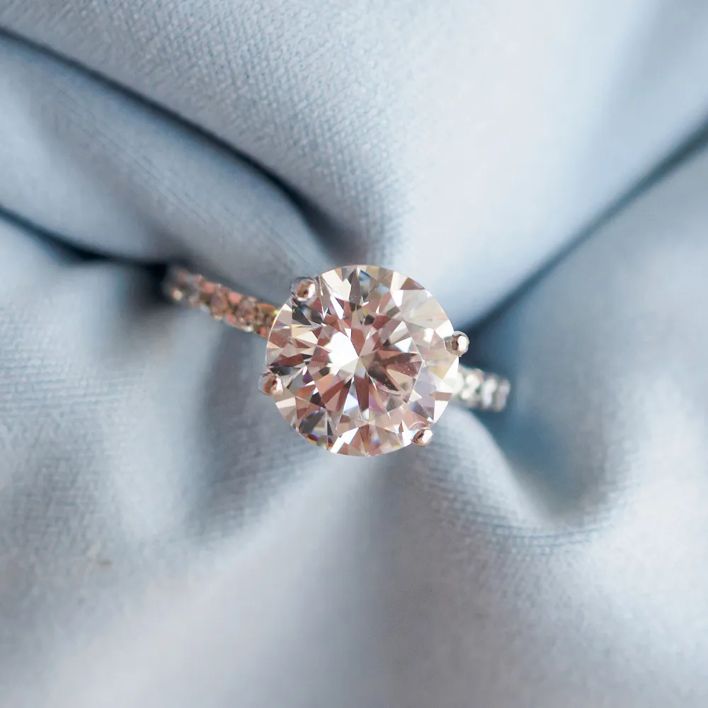 Elegant diamond engagement ring on soft blue fabric. Click to shop now at Reiniger Jewelers.
