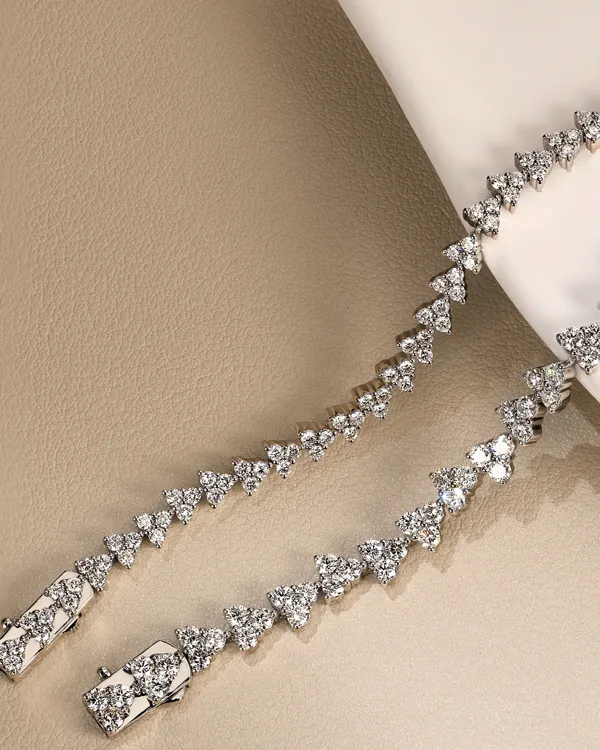 Elegant diamond tennis bracelet displayed on a neutral background. Click to learn more about our jewelry collection.