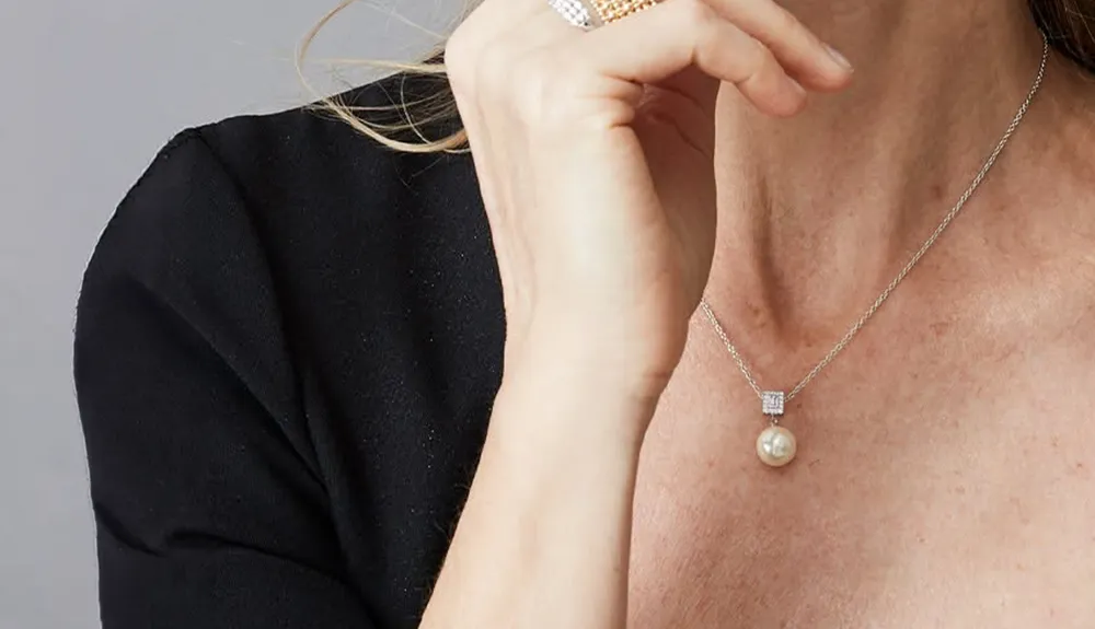 Woman wearing a diamond halo pendant necklace. Shop pendants at Renzo & Co. in Charlotte, NC