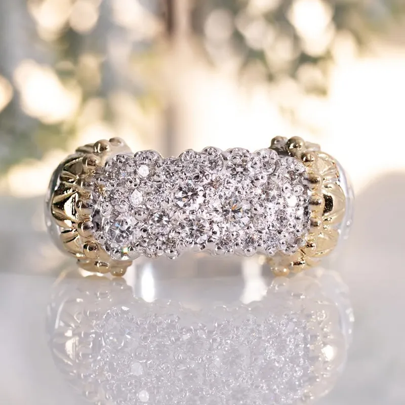 A gold and diamond encrusted ring with intricate detailing on a reflective surface.