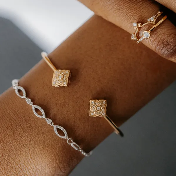 Elegant gold and silver bracelets displayed on a wrist.