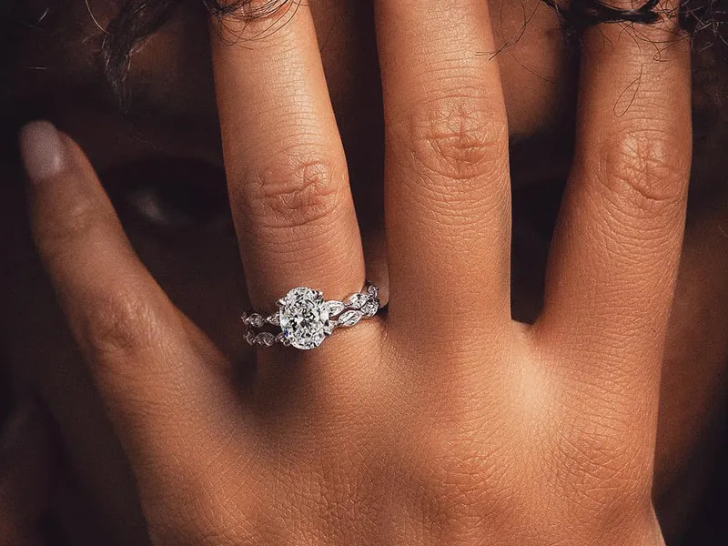Elegant diamond engagement ring on a hand, showcasing intricate design.
