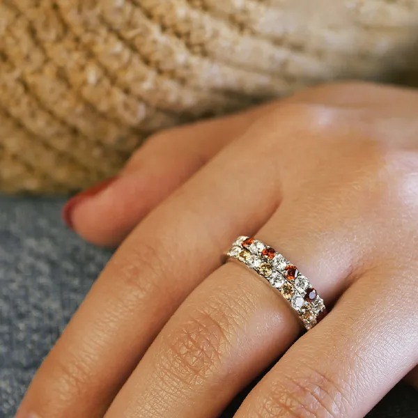 Gold and white ring with diamond accents displayed on a hand. Shop fashion rings at R. Gregory Jewelers.