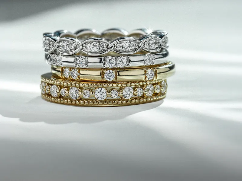 Elegant diamond engagement rings displayed on a gold surface. Click to explore more diamonds at R. Gregory Jewelers.