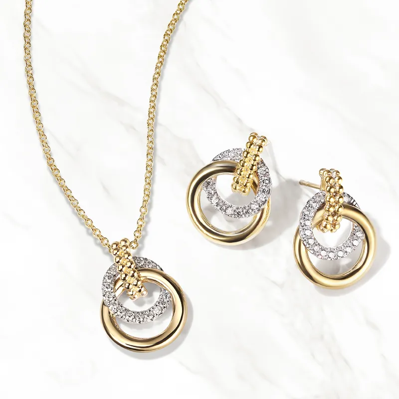 Gold and silver jewelry set featuring a necklace and matching earrings with intertwined rings and sparkling accents.
