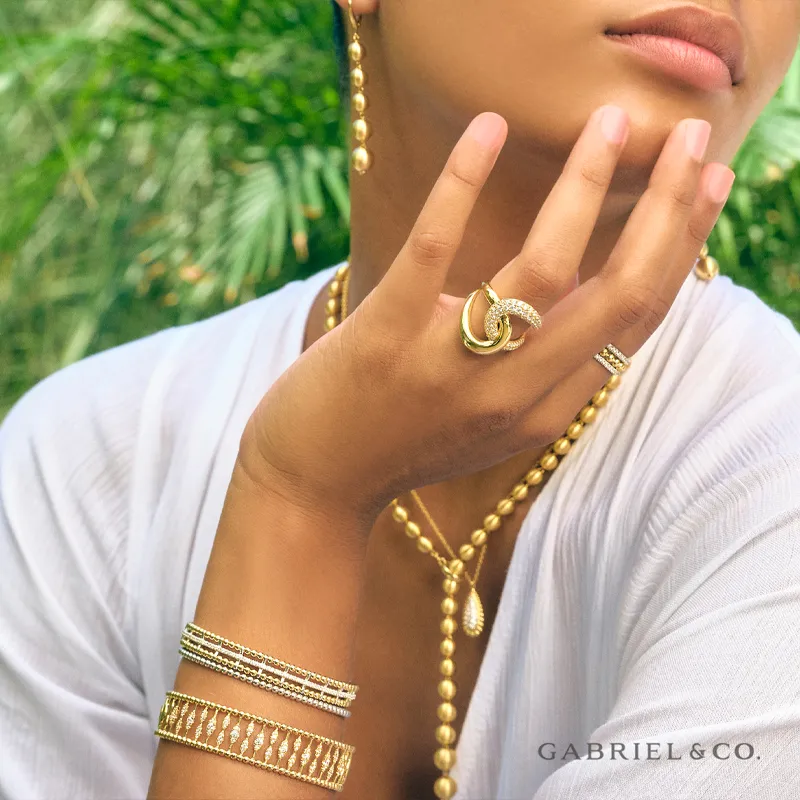 Model showcasing elegant gold jewelry including rings, bracelets, and earrings.