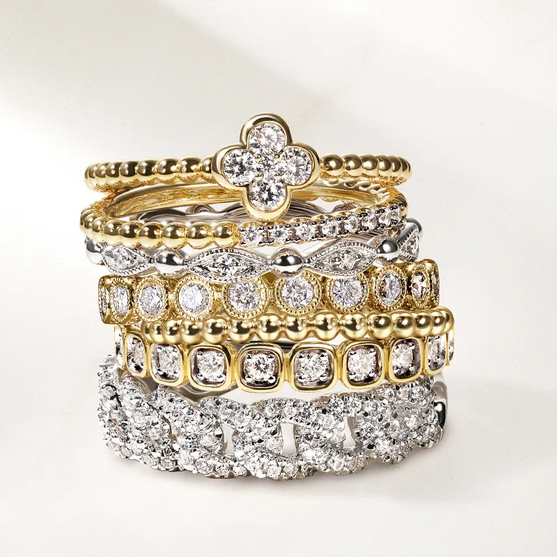 Stack of elegant gold and silver rings with diamonds, showcasing intricate designs
