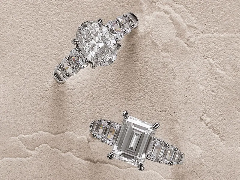 Two elegant engagement rings on a textured background. Click to shop engagement rings at R. Gregory Jewelers.
