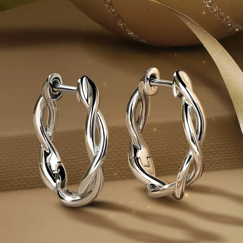 Twisted hoop earrings in silver and gold, showcasing elegant design.