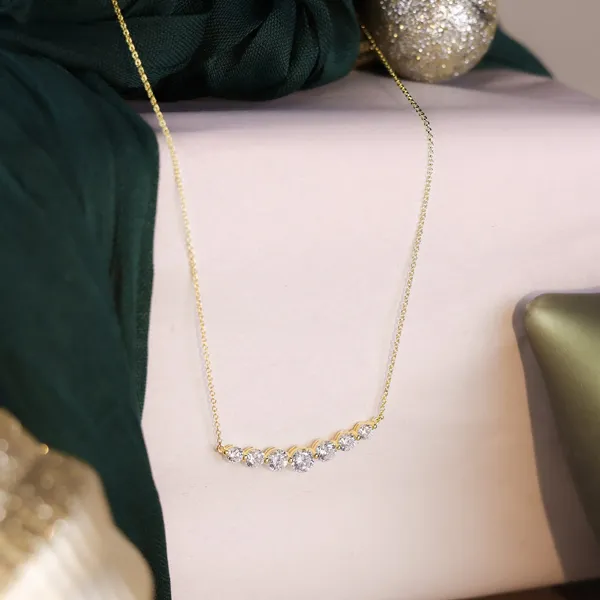 Gold necklace with five sparkling diamonds, displayed for R. Gregory Jewelers.
