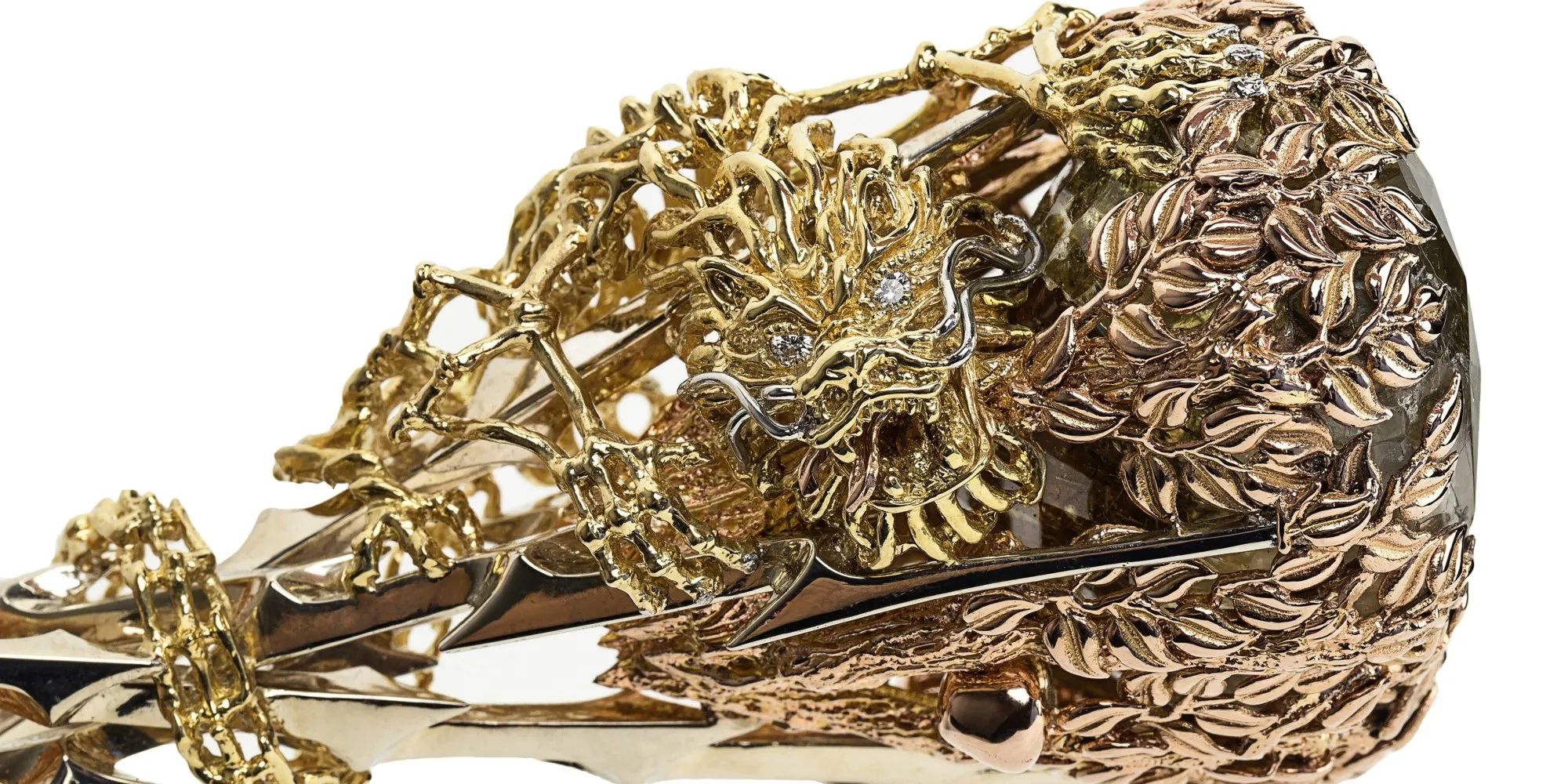 Gold floral ring with a central emerald-cut diamond and smaller diamonds, showcasing intricate design and elegance.