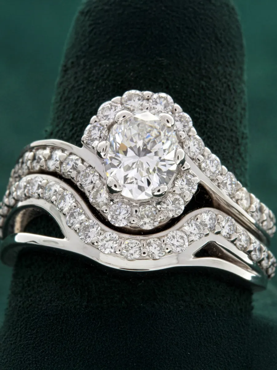 Elegant diamond engagement ring set with an oval center stone and intricate band design.