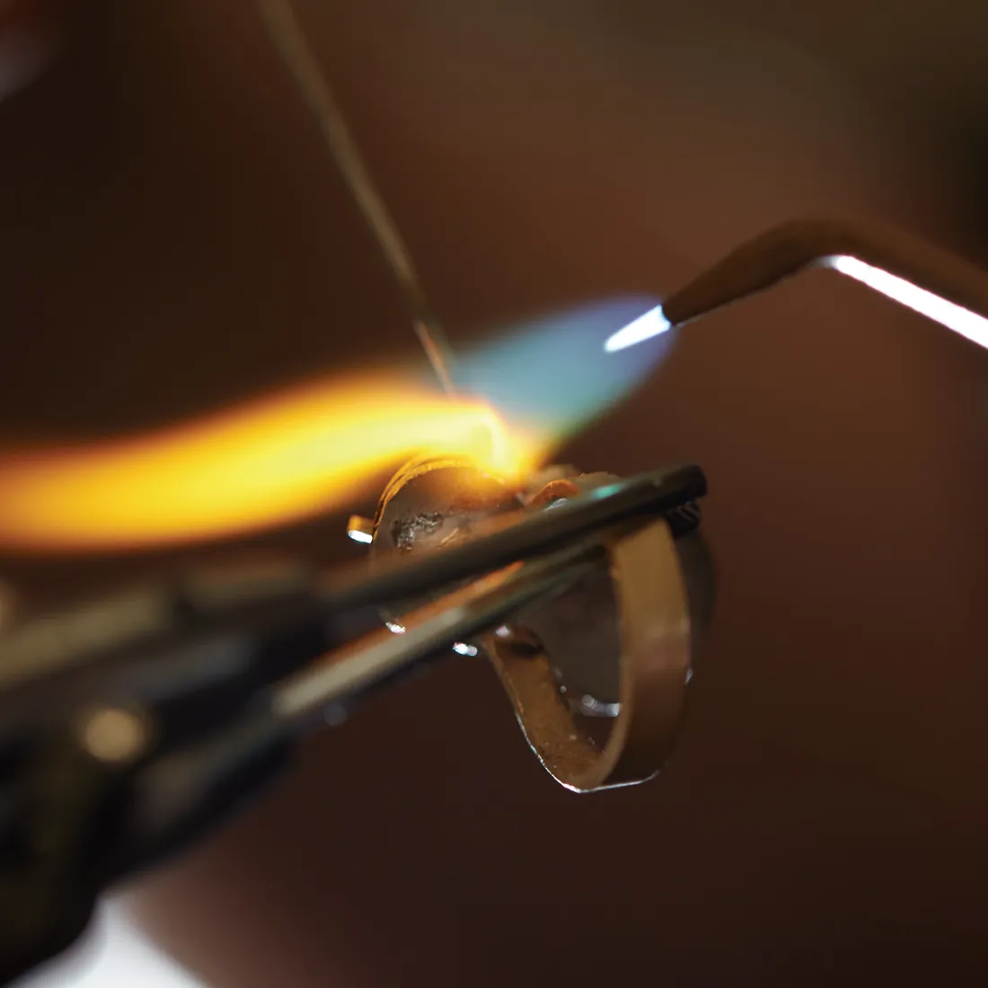 Jeweler using a torch to heat a ring for restoration at Rich Custom Jewelry in Las Vegas.