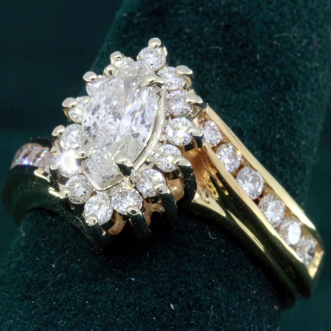 Elegant gold and diamond ring featuring a marquise center stone surrounded by a halo of smaller diamonds.