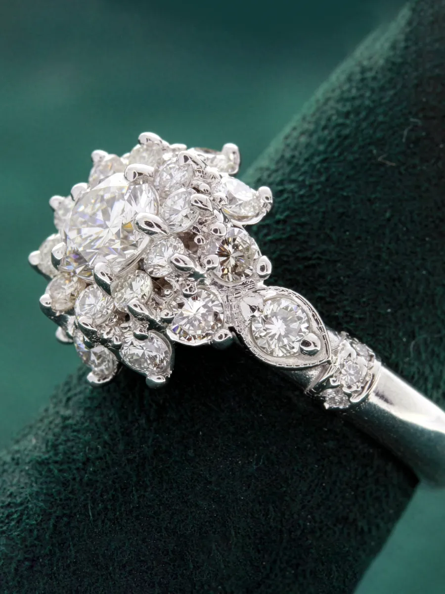 Stunning diamond cluster engagement ring displayed on a green velvet background at Rich Custom Jewelry, Las Vegas.