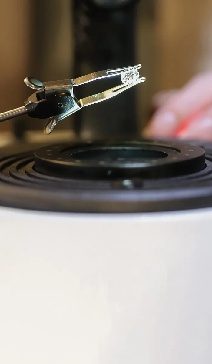 Jeweler using a tool to hold a diamond for appraisal at Rich Custom Jewelry in Las Vegas. Click to learn more.