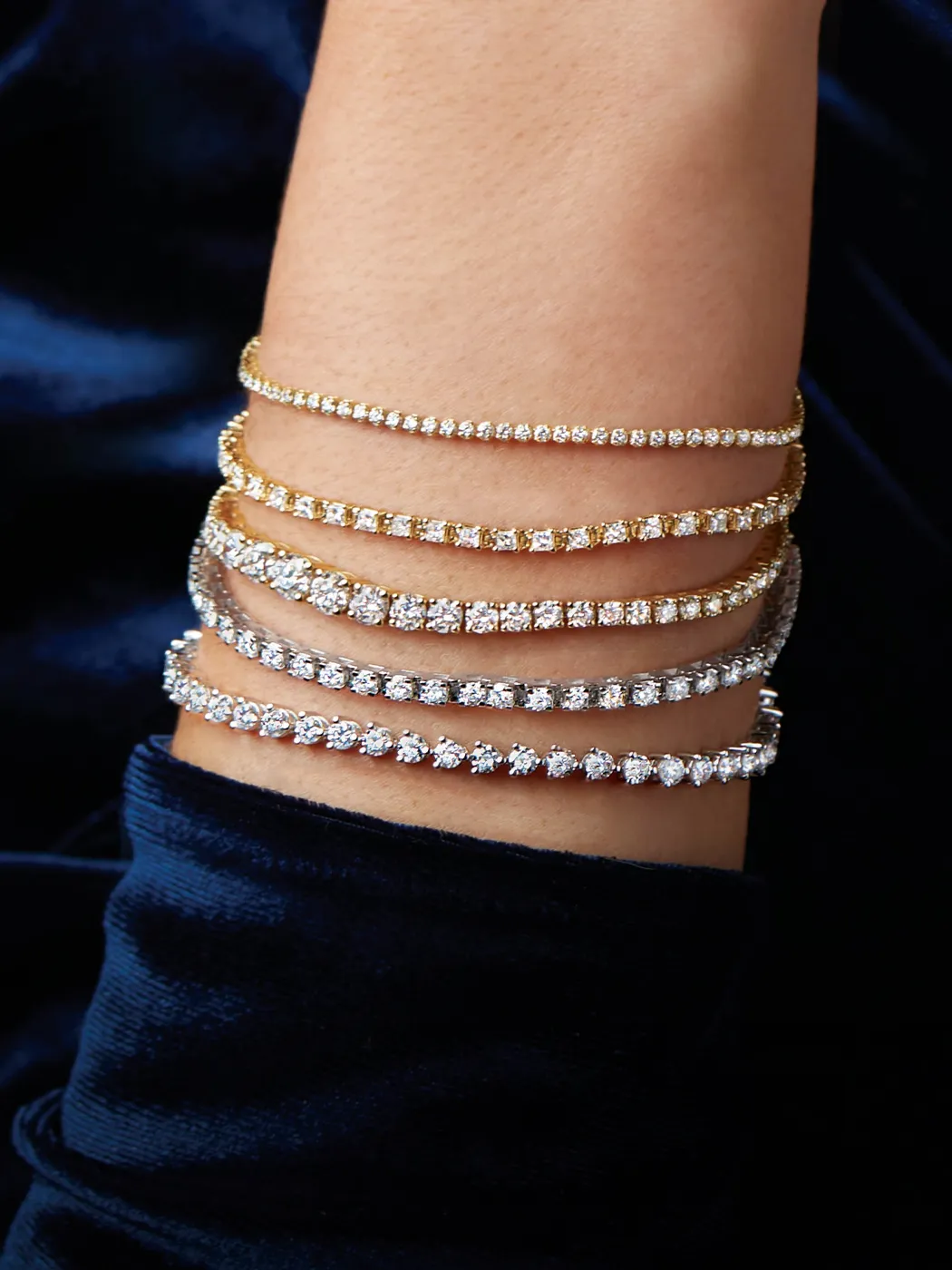 Elegant stacked bracelets in gold and silver with sparkling stones, showcasing Rich Custom Jewelry's exquisite collection.