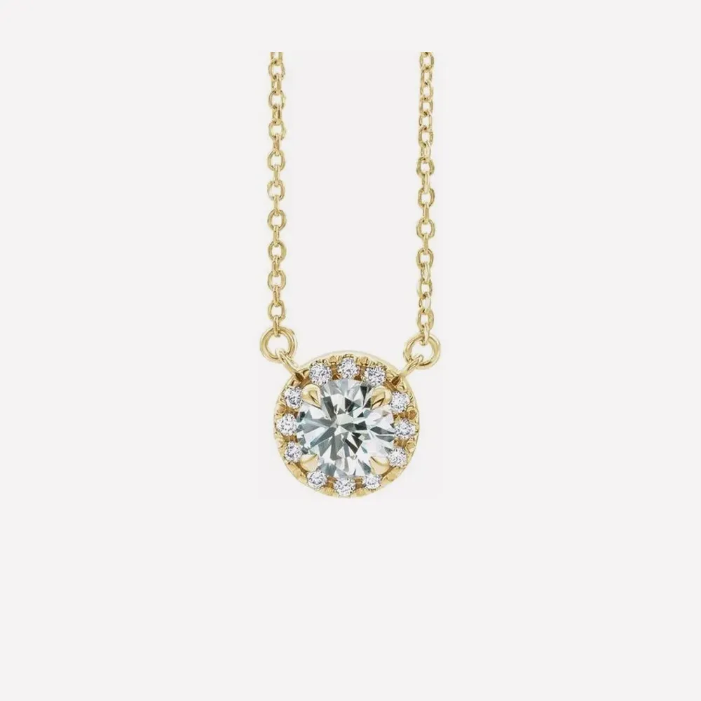 Gold necklace with a round diamond pendant surrounded by smaller diamonds. Click to explore more necklaces.