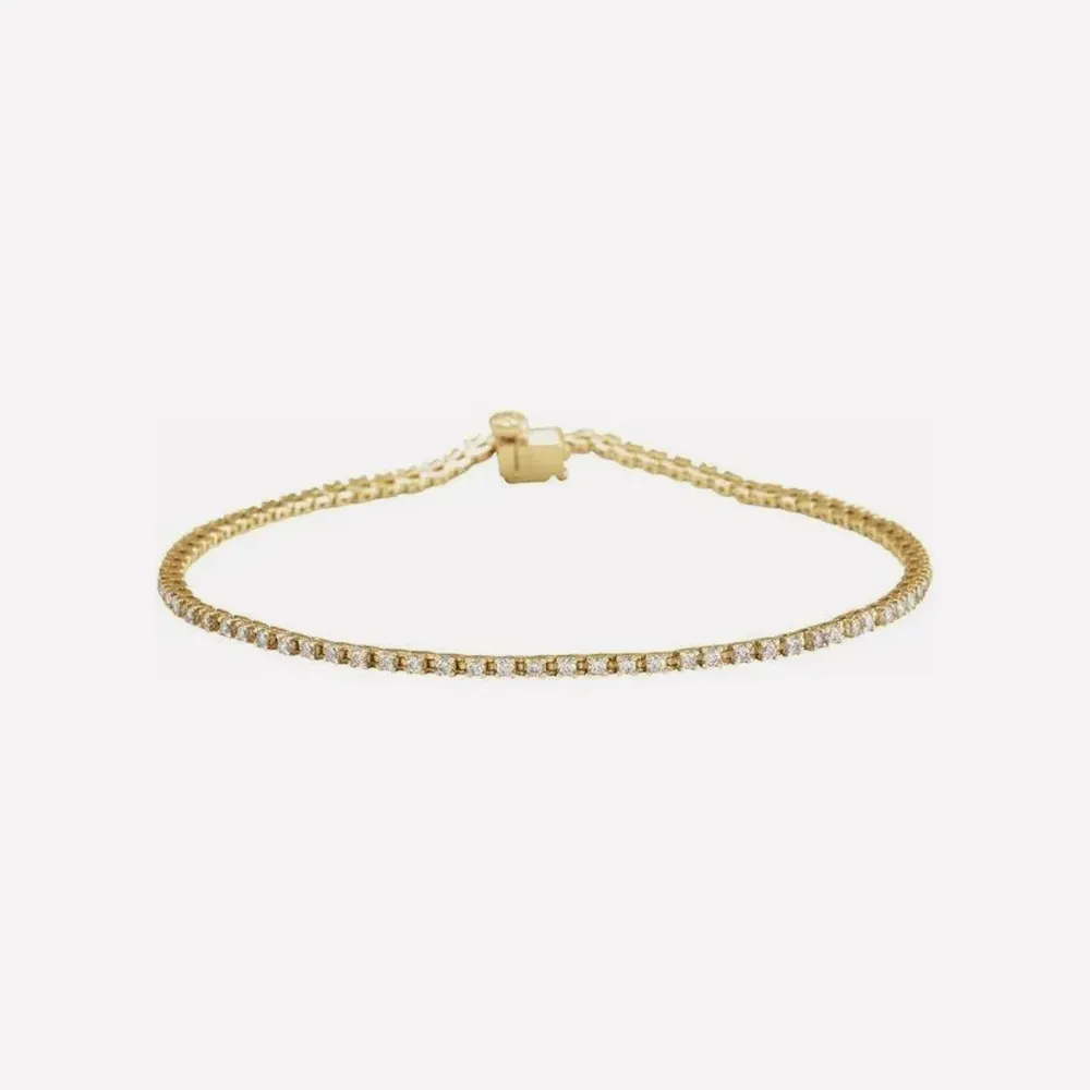 Gold tennis bracelet with diamonds on a white background. Click to explore Tennis Bracelets.