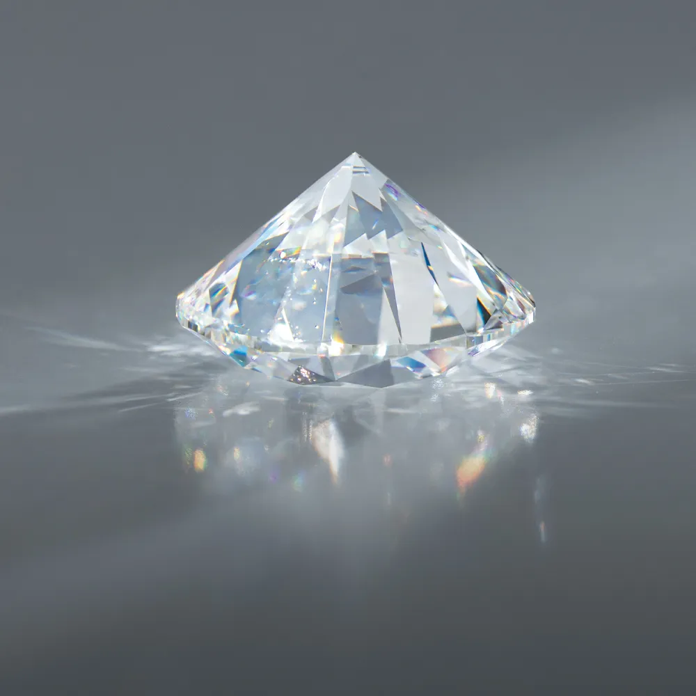 A sparkling diamond on a gray surface, reflecting light.