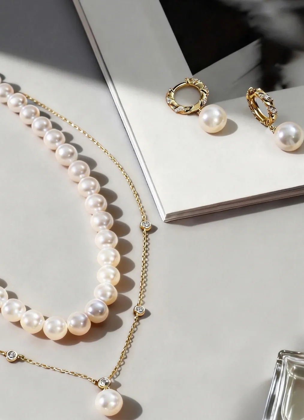 Elegant pearl necklace and earrings on a magazine, showcasing fine jewelry.